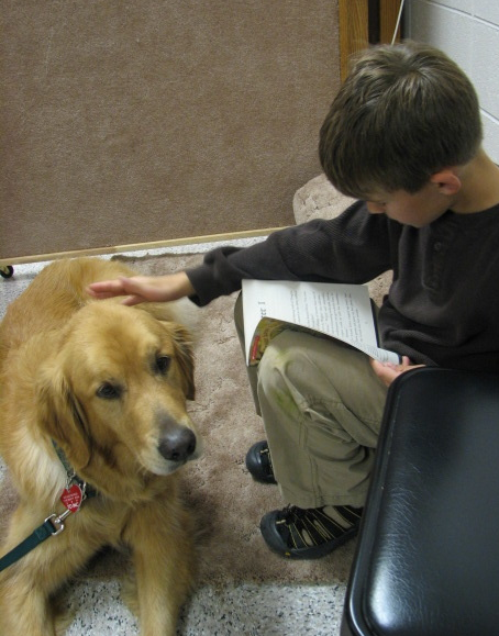 Child reading to therapy dog